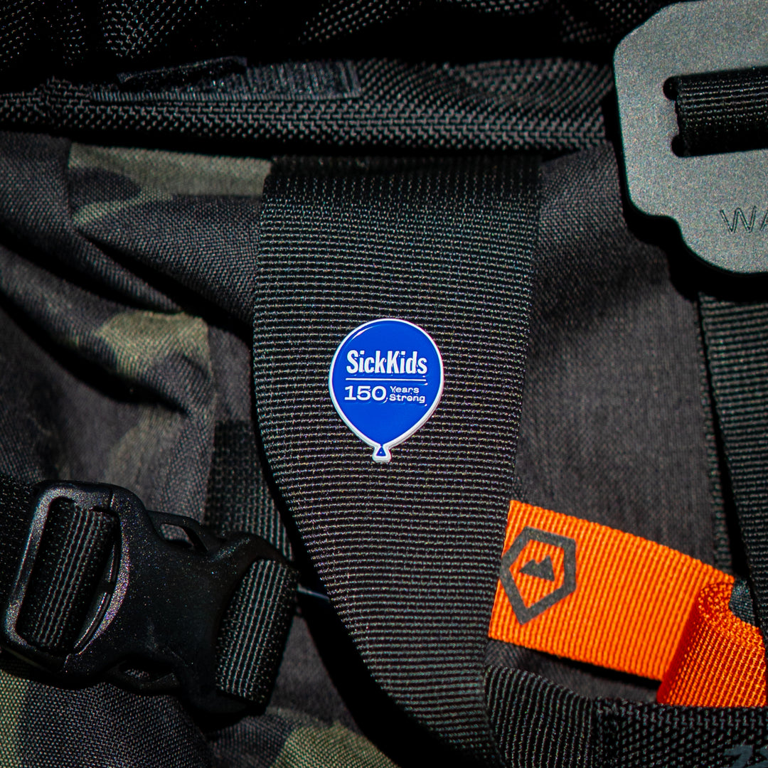 A black strap with a pin badge featuring the SickKids hospital logo to celebrate their 150 years.