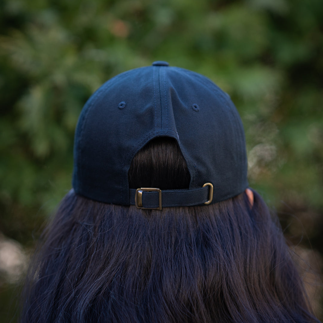 A person wearing a black baseball cap with 'SickKids 150 Years Strong' printed on the front.