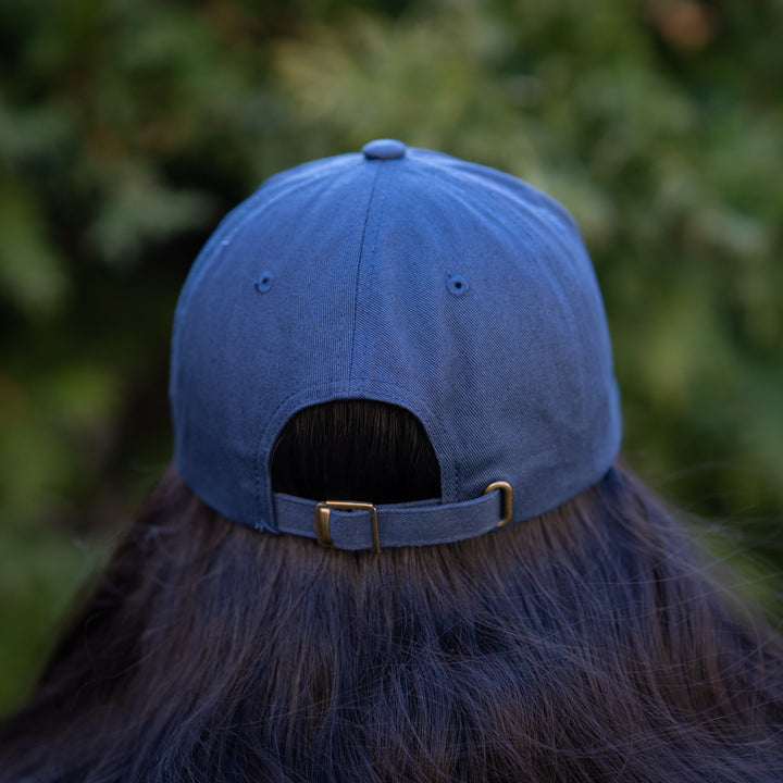 A person wearing a navy blue baseball cap with 'SickKids 150 Years Strong' printed on the front.