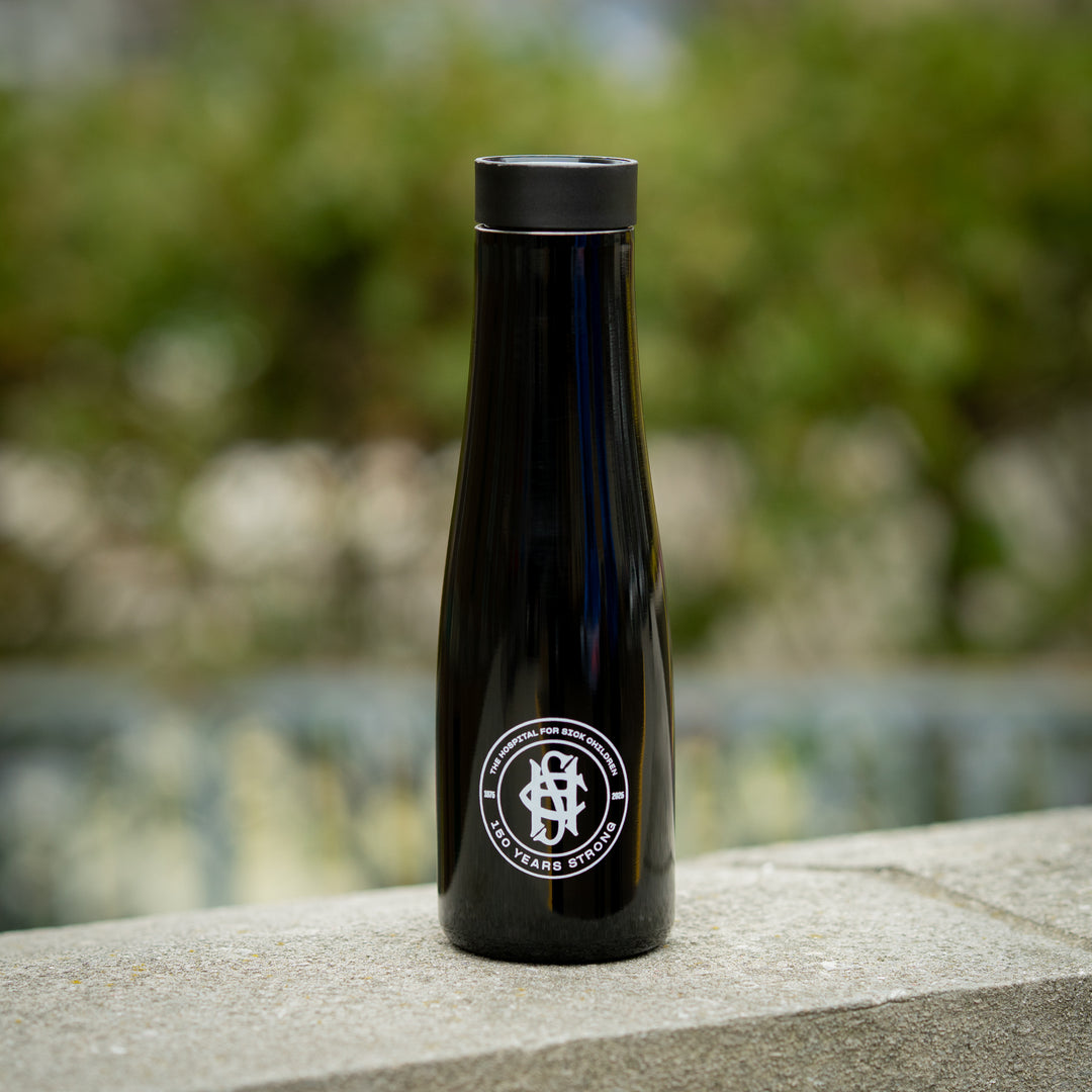 A black, double-wall stainless steel water bottle with a premium commemorative logo, featuring a spout lid for 360-degree drinking.