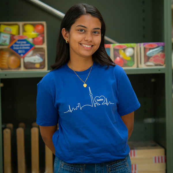 A person wearing a blue t-shirt with a skyline logo in the center.