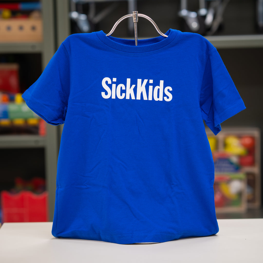 Blue t-shirt with 'SickKids' text on a hanger against a blurred background