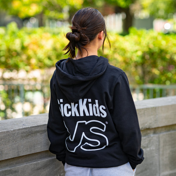 Person wearing a black hoodie with 'SickKids VS' branding outdoors